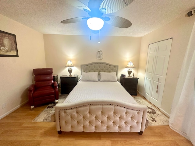 bedroom featuring a textured ceiling, a closet, ceiling fan, and light hardwood / wood-style flooring