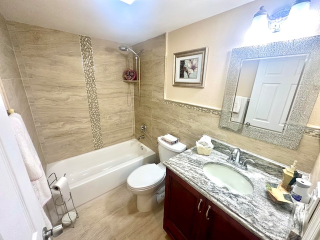 full bathroom featuring hardwood / wood-style floors, tile walls, tiled shower / bath, toilet, and large vanity