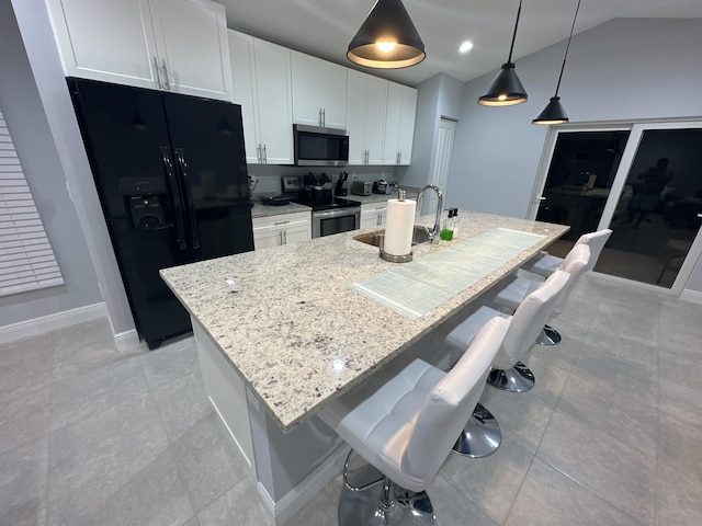 kitchen with a breakfast bar area, a kitchen island with sink, stainless steel appliances, a sink, and white cabinets