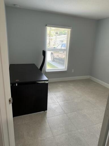 office space with light tile patterned floors and baseboards