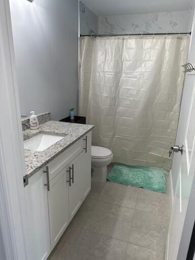 full bathroom featuring toilet, vanity, and a shower with shower curtain