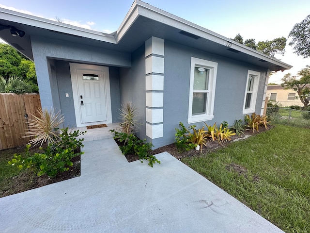 property entrance featuring a lawn