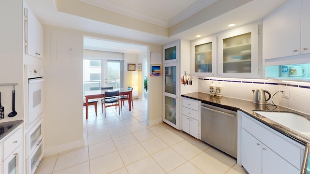 kitchen featuring dishwasher, backsplash, white oven, ornamental molding, and white cabinetry