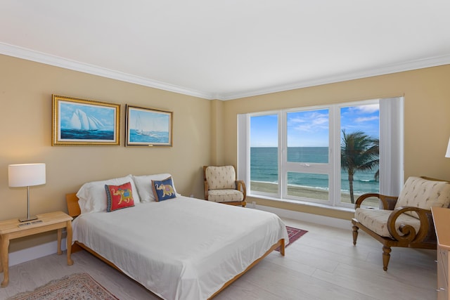 bedroom with light hardwood / wood-style floors, a water view, and ornamental molding