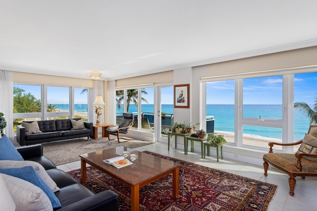 tiled living room featuring a view of the beach and a water view