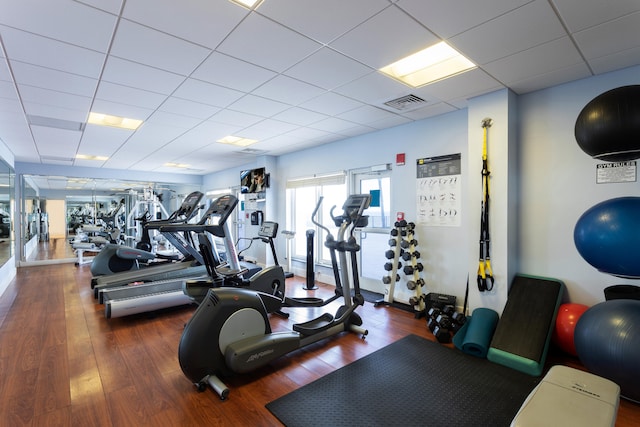 gym with hardwood / wood-style floors and a paneled ceiling