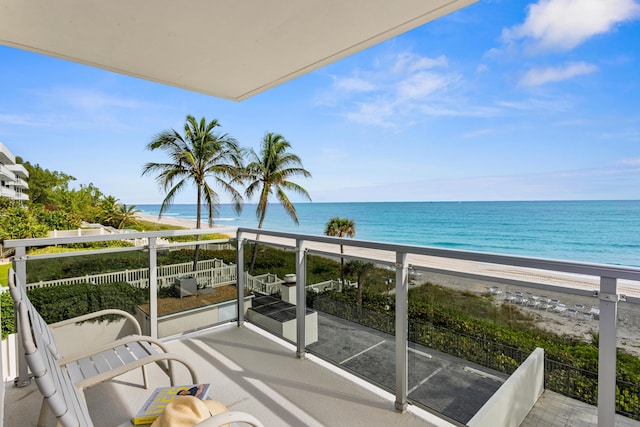 balcony with a water view and a beach view