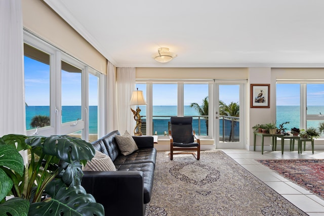 living room with light tile patterned floors, a water view, and a wealth of natural light