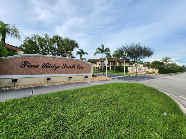 community sign featuring a yard