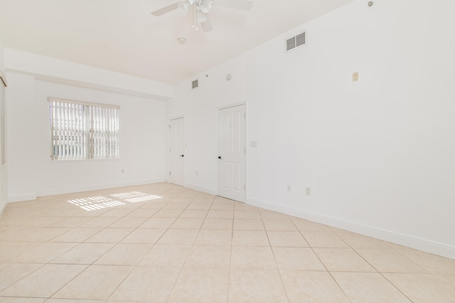 tiled spare room with ceiling fan