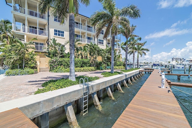 view of dock with a balcony and a water view