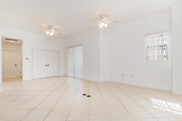 tiled spare room with ceiling fan