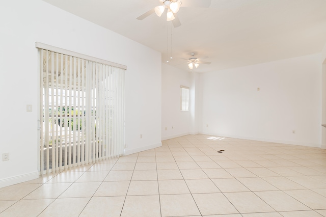 tiled spare room featuring plenty of natural light and ceiling fan