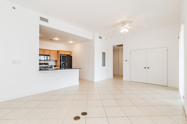 unfurnished living room featuring light tile flooring and ceiling fan