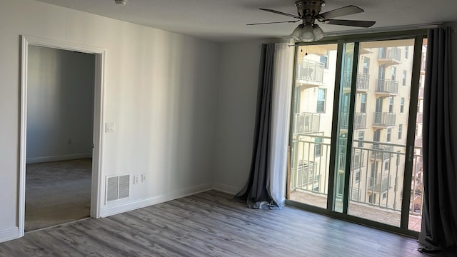 carpeted spare room featuring plenty of natural light and ceiling fan