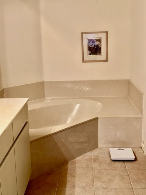 bathroom with a bathtub, vanity, and tile patterned floors