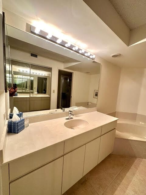 bathroom featuring a washtub, vanity, and tile patterned floors