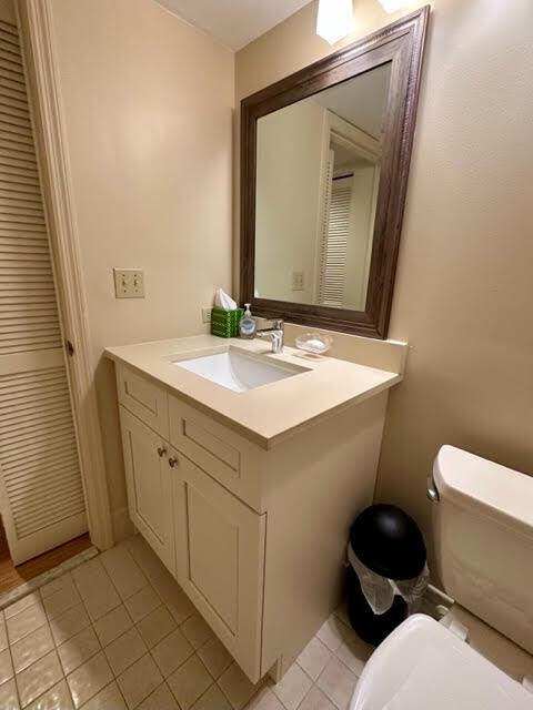 bathroom with tile patterned flooring, toilet, and vanity