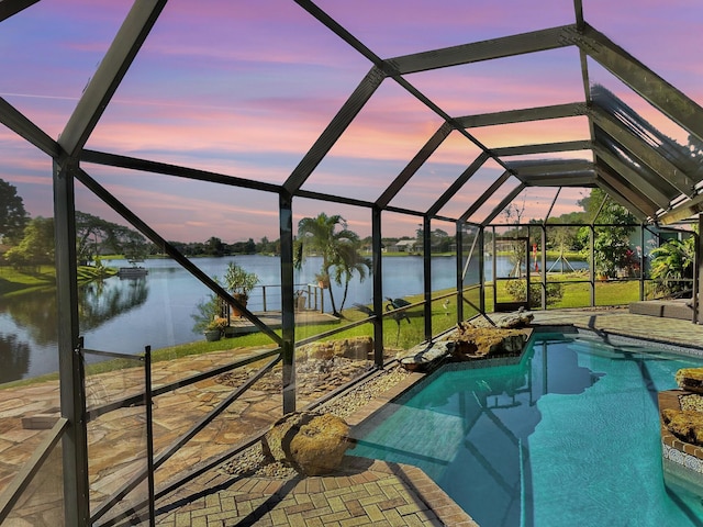 pool at dusk with a water view and glass enclosure