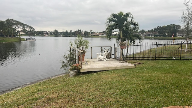 dock area featuring a lawn and a deck with water view