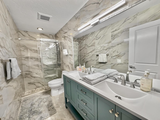 bathroom with toilet, a textured ceiling, walk in shower, and vanity