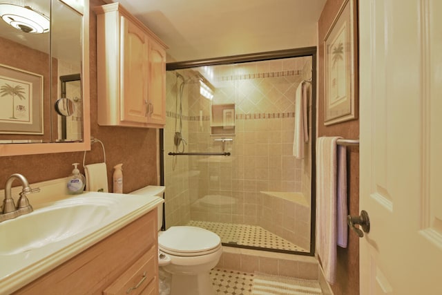 bathroom featuring tile patterned floors, an enclosed shower, vanity, and toilet