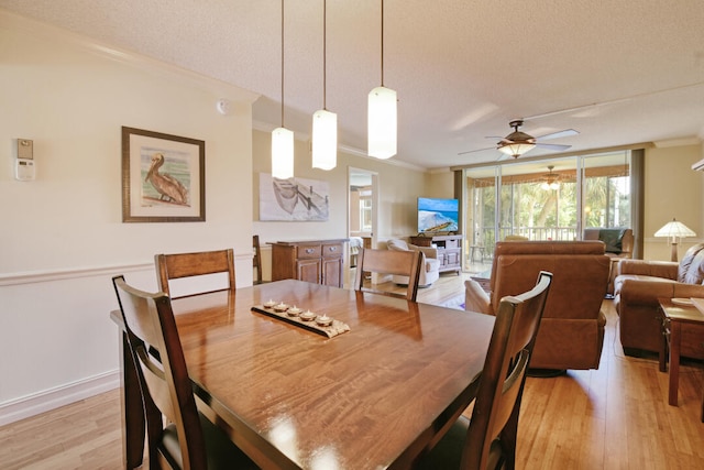 dining area with ceiling fan, a textured ceiling, light hardwood / wood-style flooring, and crown molding