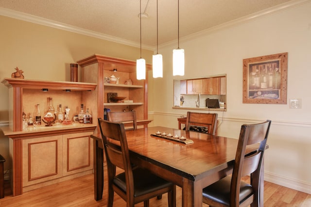 dining area featuring ornamental molding and light wood-type flooring