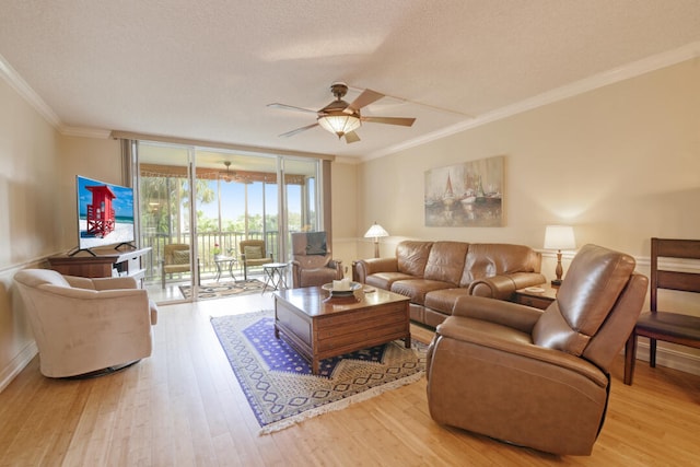 living room featuring light hardwood / wood-style flooring, ceiling fan, ornamental molding, and a textured ceiling