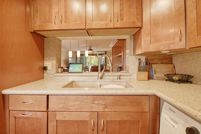 kitchen featuring light stone counters, sink, backsplash, white dishwasher, and ceiling fan