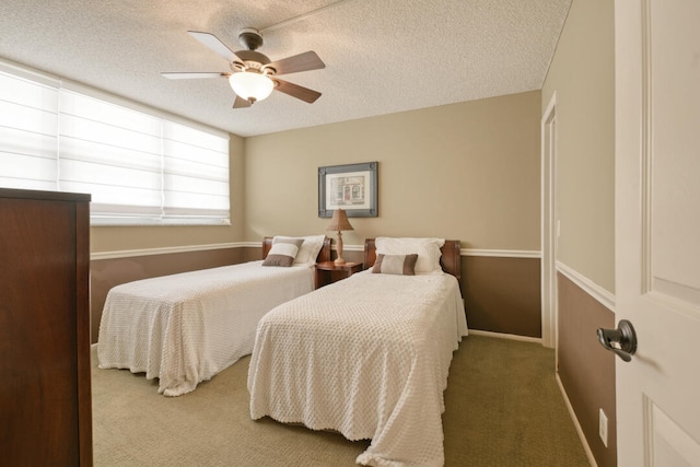 carpeted bedroom with ceiling fan and a textured ceiling