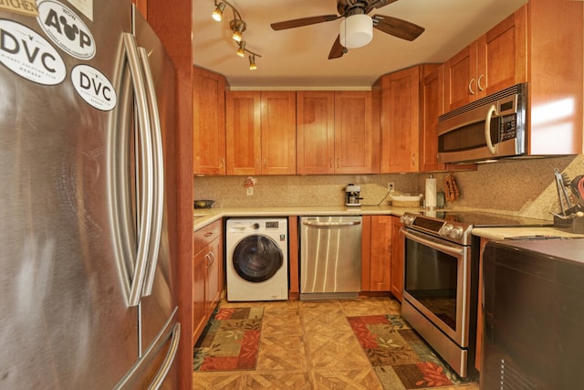 kitchen featuring washer / clothes dryer, stainless steel appliances, backsplash, ceiling fan, and light parquet floors