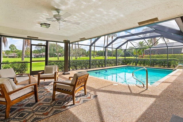 view of swimming pool featuring glass enclosure, ceiling fan, and a patio area