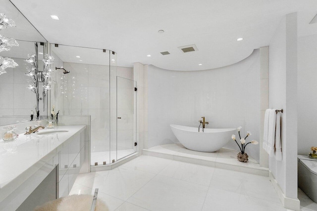 bathroom featuring tile patterned flooring, vanity, and shower with separate bathtub