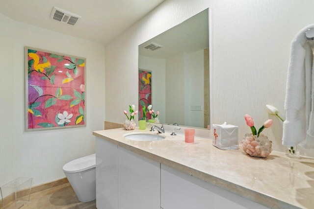 bathroom with tile patterned flooring, vanity, and toilet