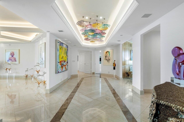 foyer entrance featuring a raised ceiling and crown molding