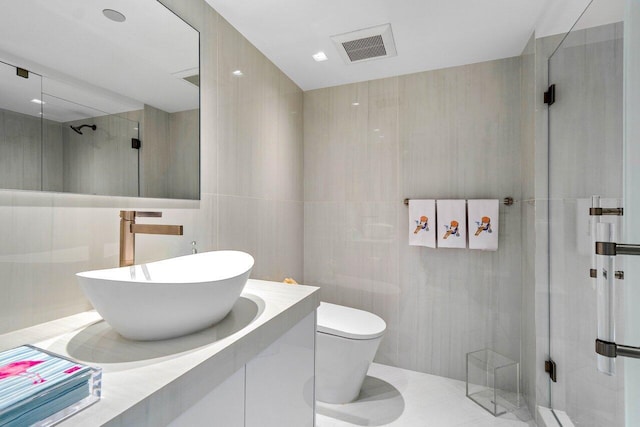 bathroom with vanity, a shower with shower door, tile walls, and toilet