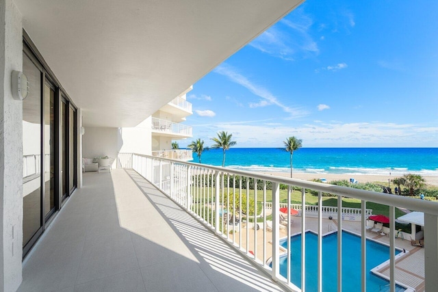 balcony featuring a water view and a beach view