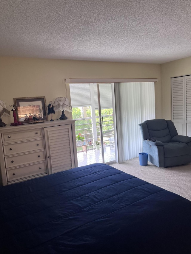 carpeted bedroom featuring access to outside, a closet, and a textured ceiling