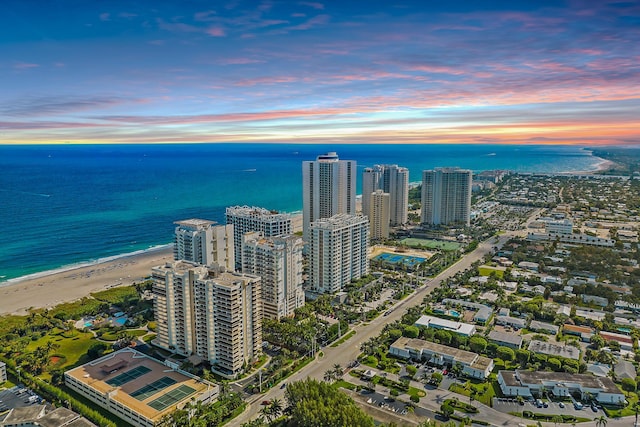 drone / aerial view with a water view, a view of the beach, and a city view