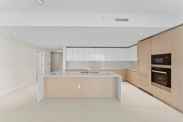 kitchen featuring white cabinets, a center island with sink, black appliances, and modern cabinets