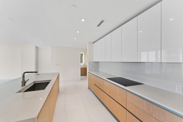 kitchen with light countertops, white cabinets, a sink, and modern cabinets