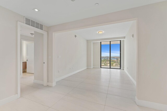 spare room with light tile patterned flooring and expansive windows