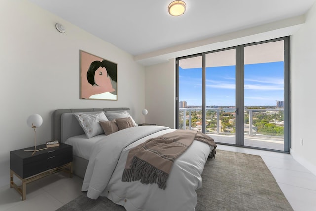 bedroom featuring light tile patterned floors, a view of city, and access to exterior