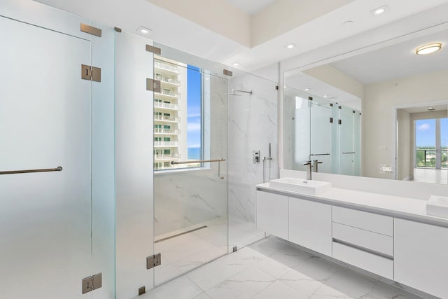 bathroom with marble finish floor, a marble finish shower, vanity, and recessed lighting