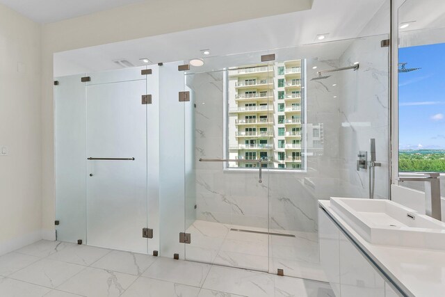 bathroom featuring a shower with shower door, vanity, and tile patterned floors