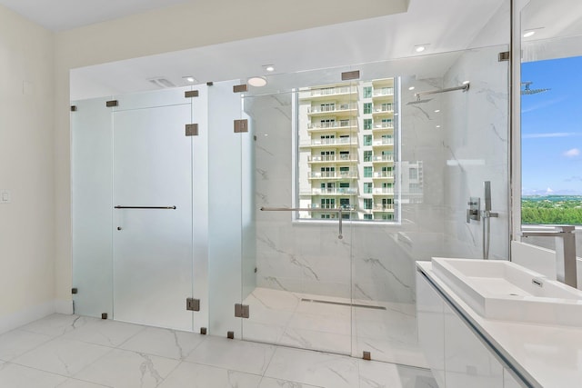 bathroom with marble finish floor, a marble finish shower, and vanity