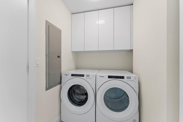 clothes washing area featuring cabinets, electric panel, and independent washer and dryer