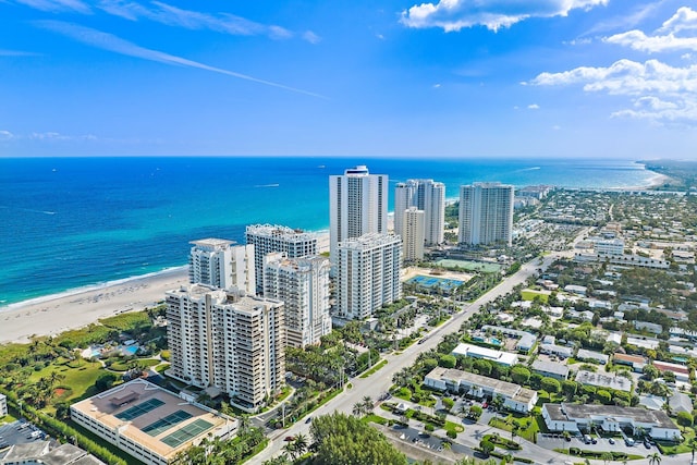 drone / aerial view with a water view, a beach view, and a city view