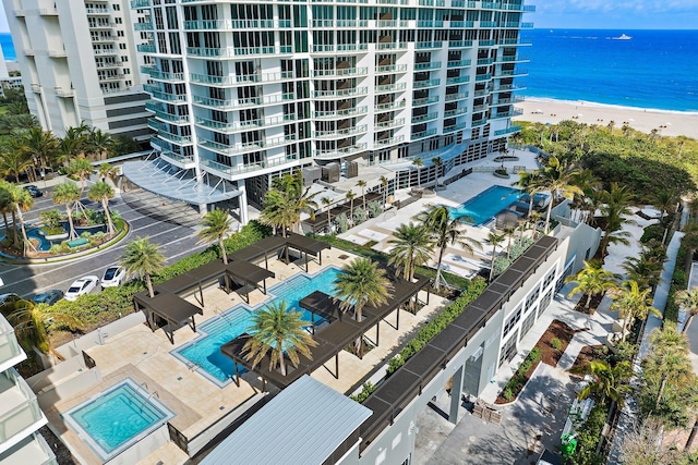 drone / aerial view featuring a beach view and a water view